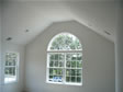 Cathedral ceilings and large circle top window are focal points for this master bedroom